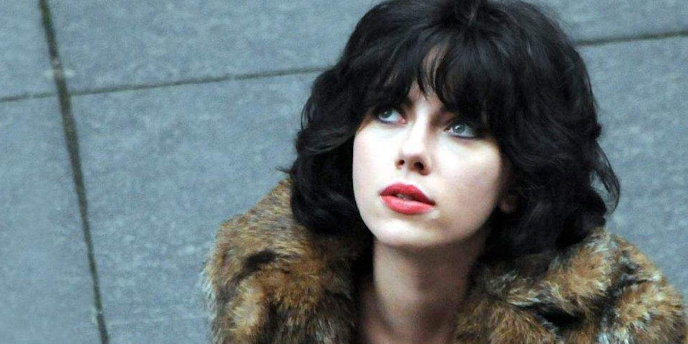 Scarlett Johansson, wearing a fur coat, looks up while outside on a street in Under the Skin