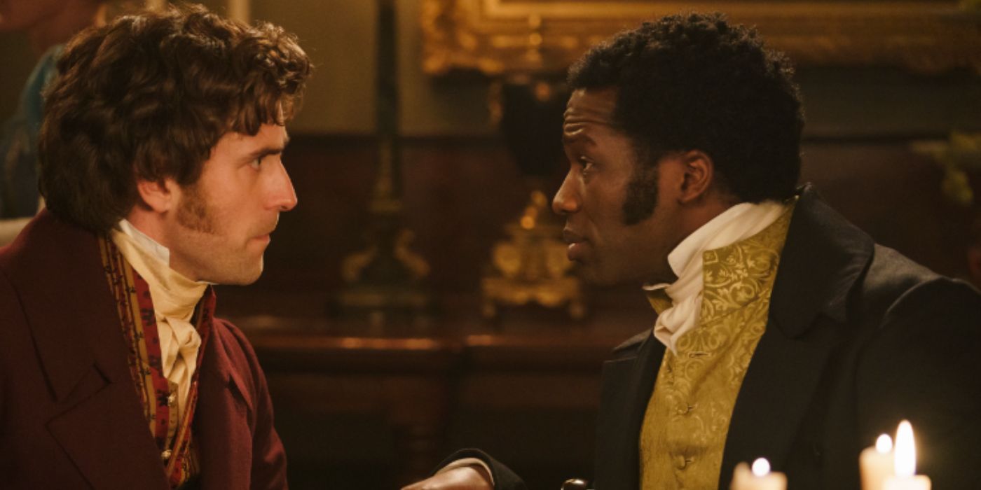 Oliver Jackson-Cohen and Sope Dirisu as Lord Cassidy and Mr. Malcolm sitting at a table wearing a red and golden suit in 'Mr. Malcolm's List'