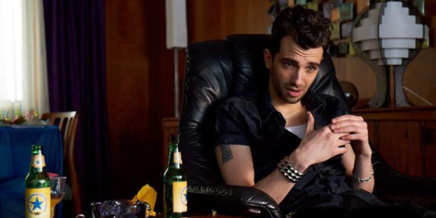 Jay Baruchel as Francie sitting down at a table frowning in a black shirt in 'The Art of the Steal'