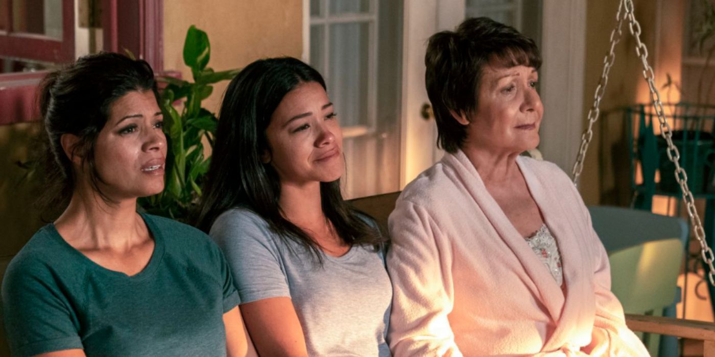 Andrea Nevado, Gina Rodriguez, Ivonne Coll as Xiomara, Jane, and Alba, sitting on a bench outside their home in 'Jane the Virgin'