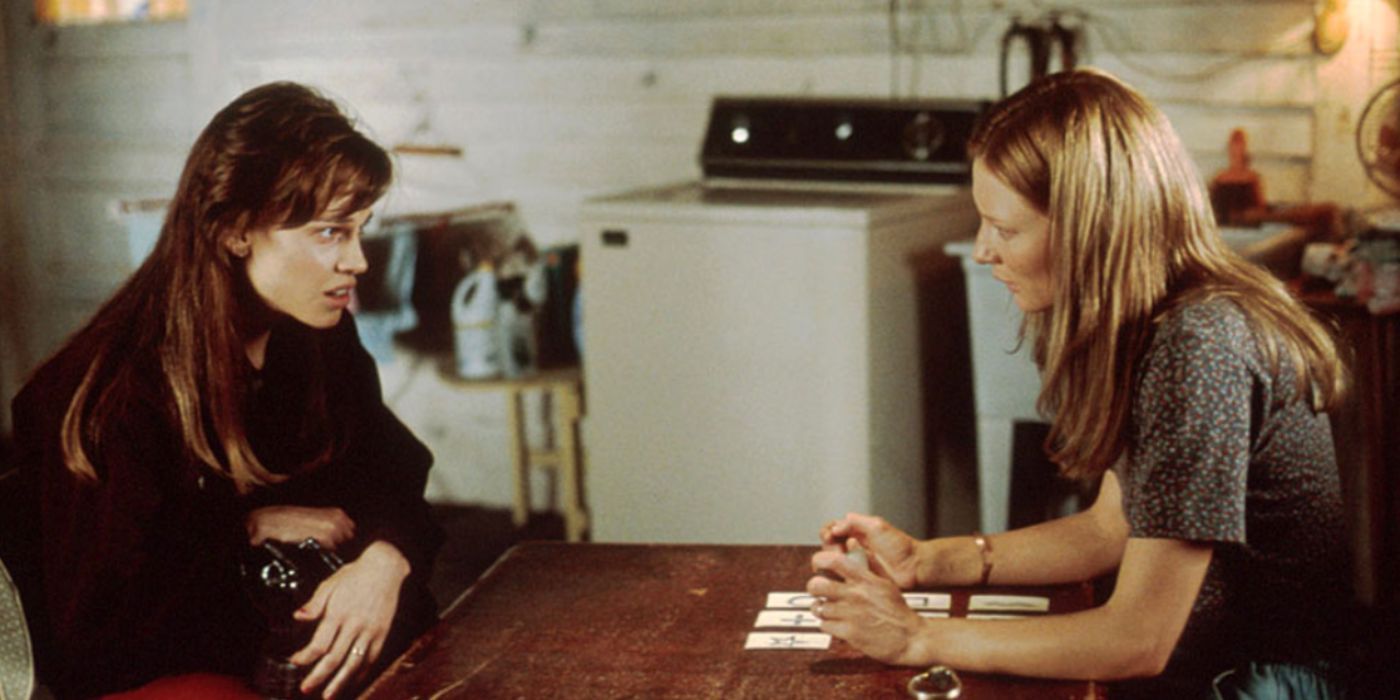 Hilary Swank and Cate Blanchett as Valerie and Annie sit at a table with cards in “The Gift”