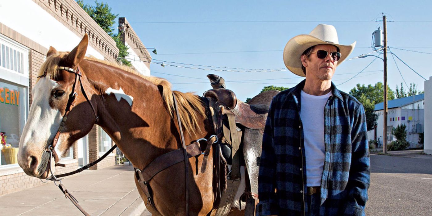 Kevin Bacon as Dick wearing a cowboy hat standing next to a horse in 'I Love Dick'