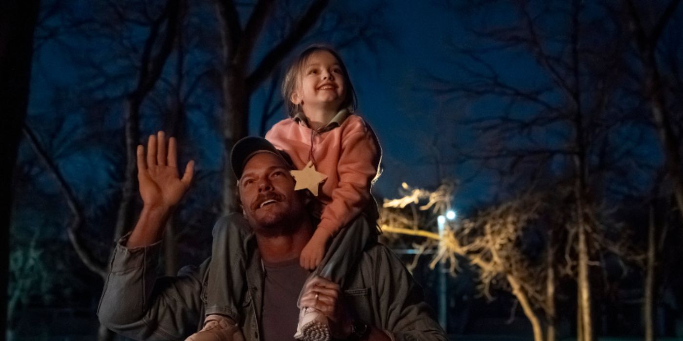 Alan Ritchson as Ed with his daughter michelle on his shoulders staring up at the night sky in 'Ordinary Angels'