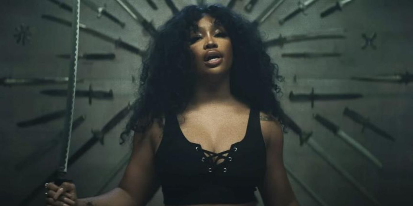 SZA holding a katana standing in front of a wall full of knives in the "Kill Bill' video