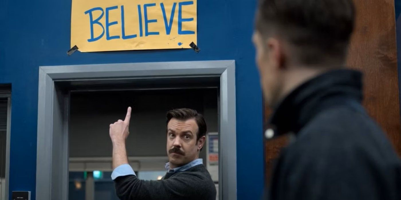 Ted Lasso (Jason Sudeikis) points at his &ldquo;Believe&rdquo; poster in front of Jamie Tartt (Phil Dunster) in &lsquo;Ted Lasso&rsquo;