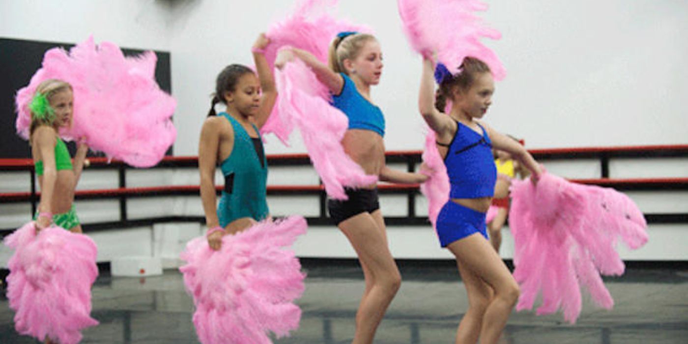 The ALDC dancers hold pink feathery props during rehearsal in 'Dance Moms'