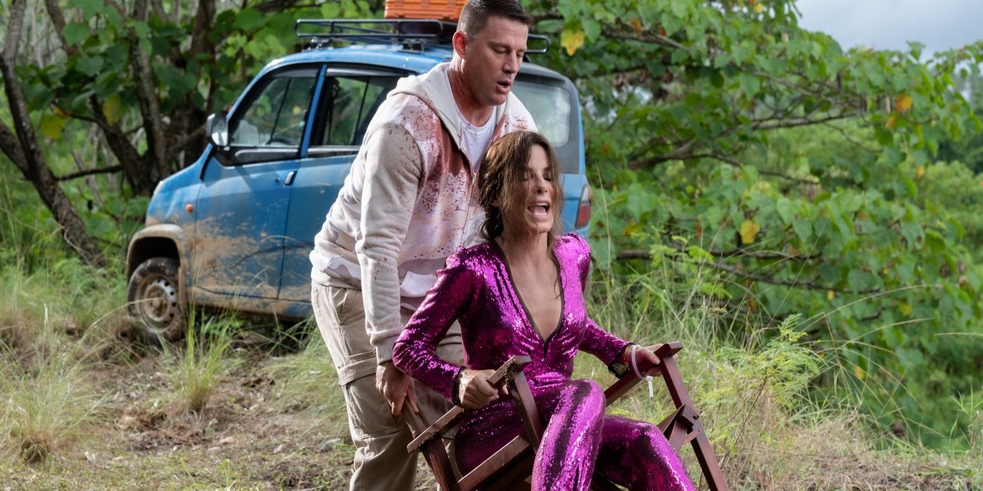 Channing Tatum's Alan pushing Sandra Bullock's Loretta in a chair in the jungle in The Lost City