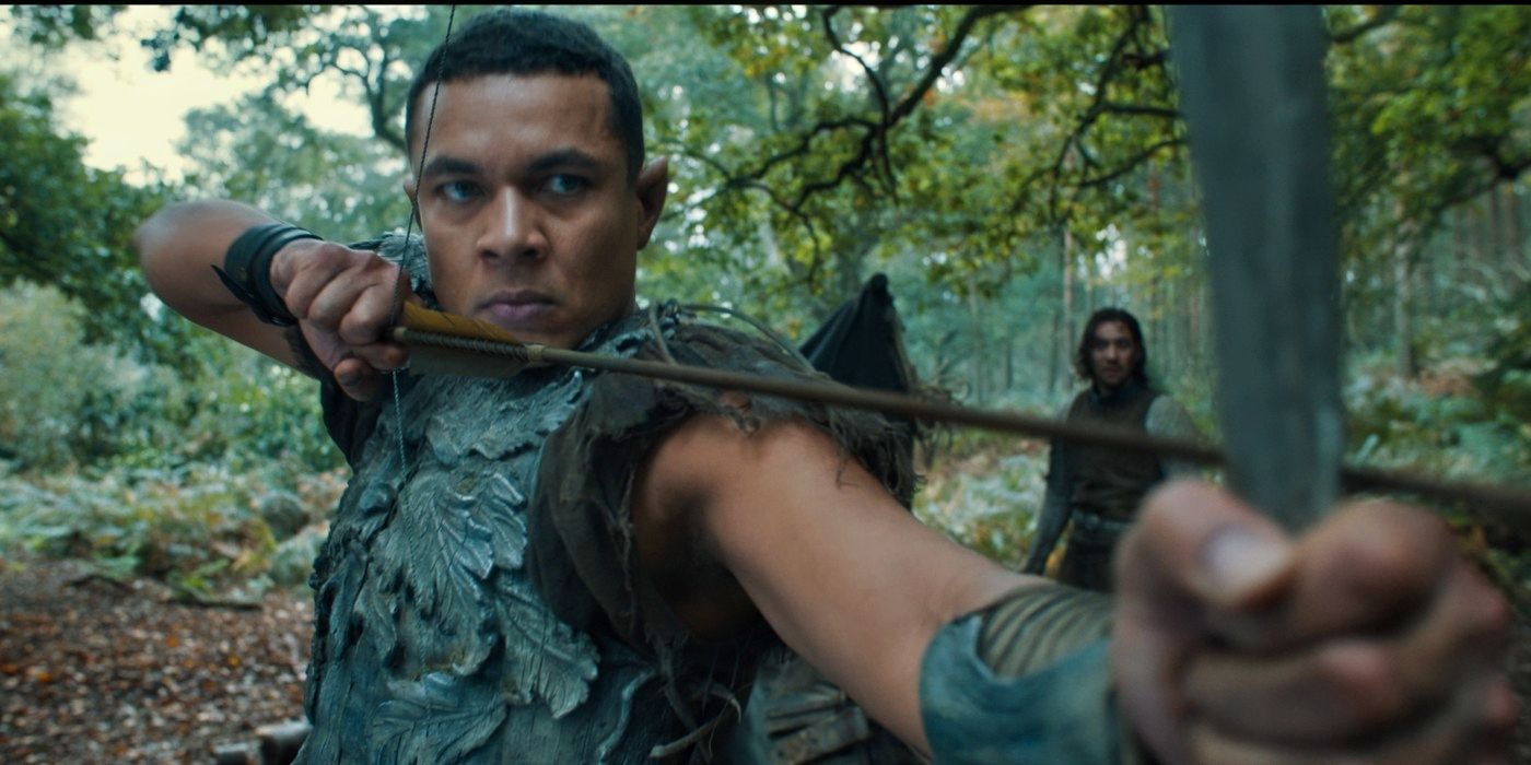 Ismael Cruz Córdova notching an arrow as Arondir as Maxim Baldry's Isildur watches on in 'The Rings of Power' Season 2