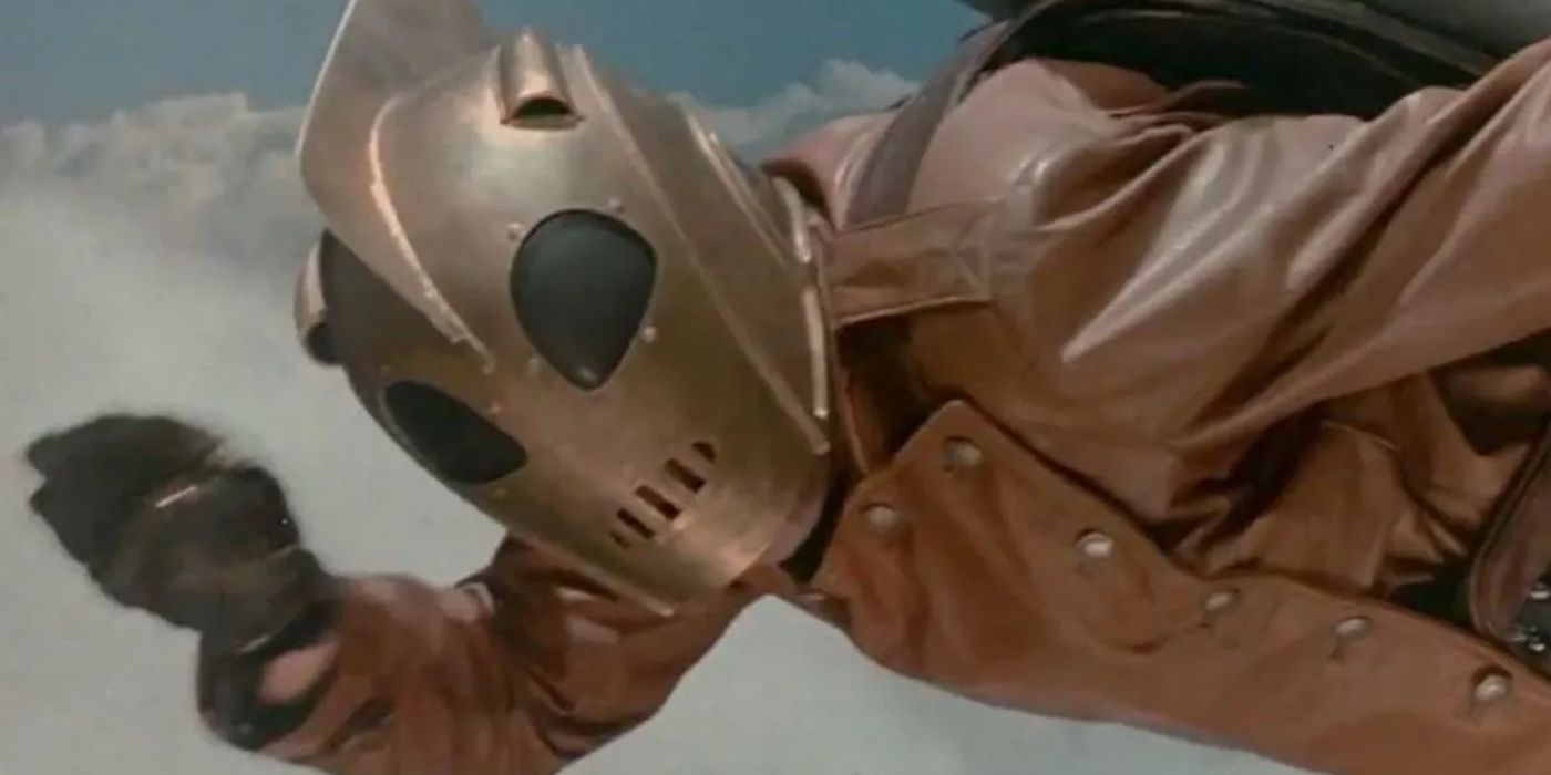 A masked superhero in a leather jacket flies through the sky in 'The Rocketeer' (1991).