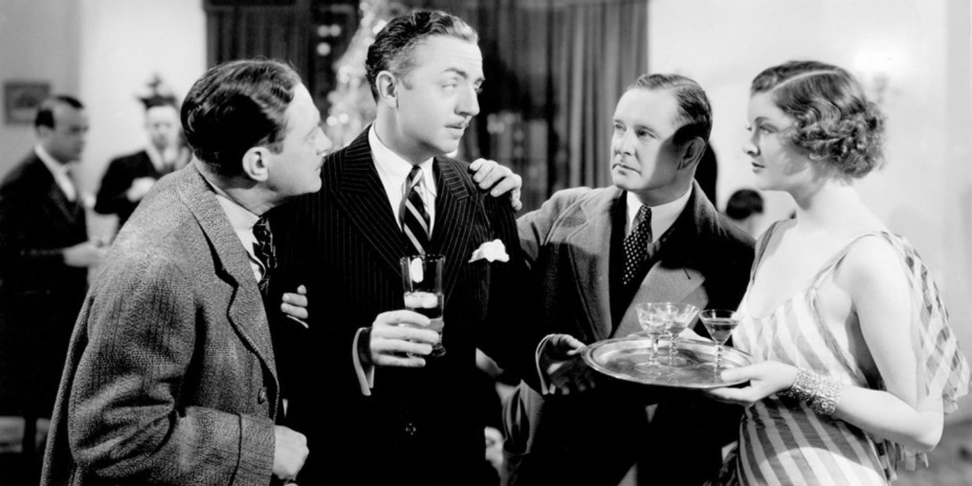 A group of well dressed people at a party stand together talking in The Thin Man.