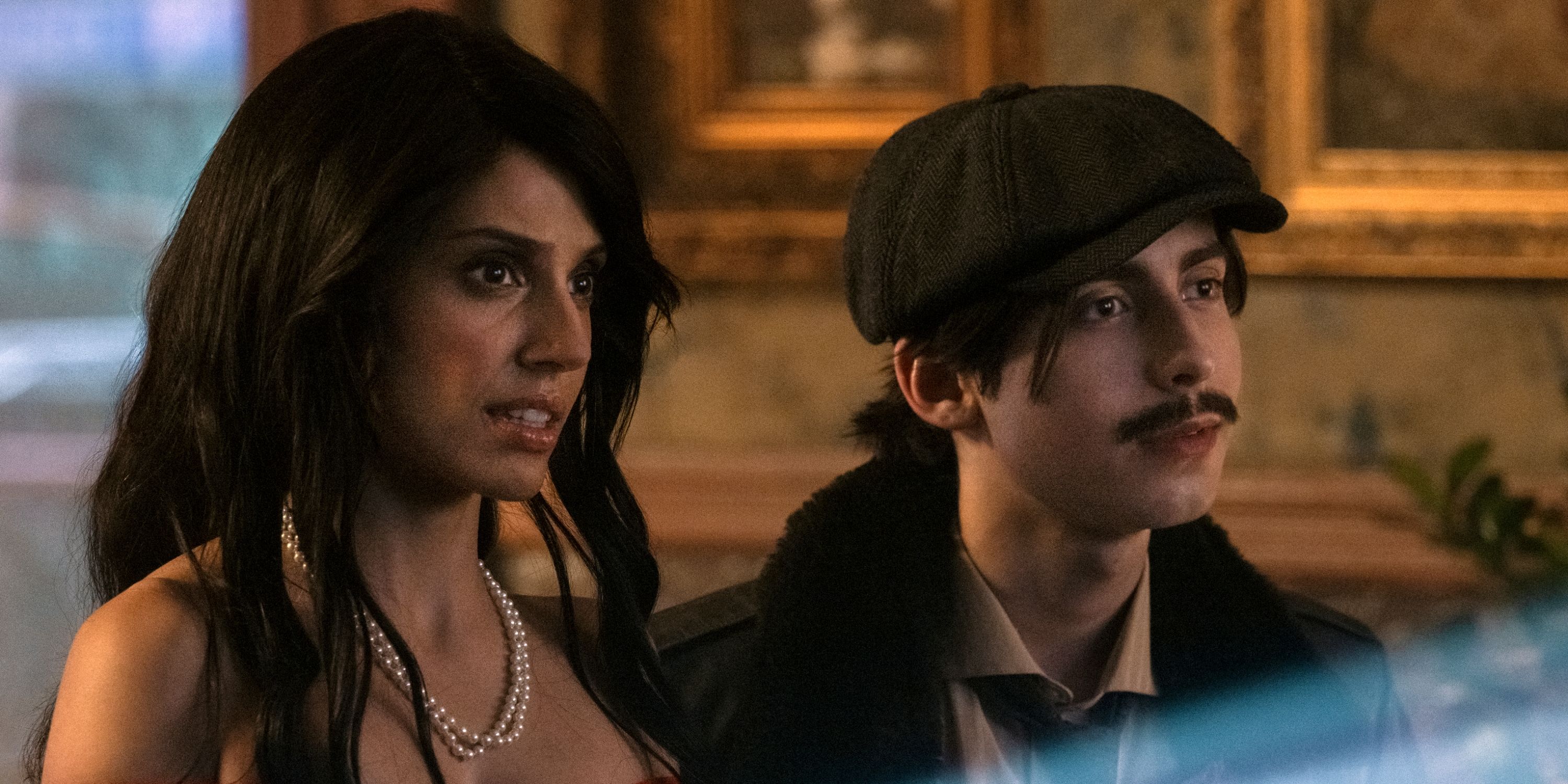 Ritu Arya as Lila wearing a pearl necklace with Aidan Gallagher as Five in a mustache in The Umbrella Academy