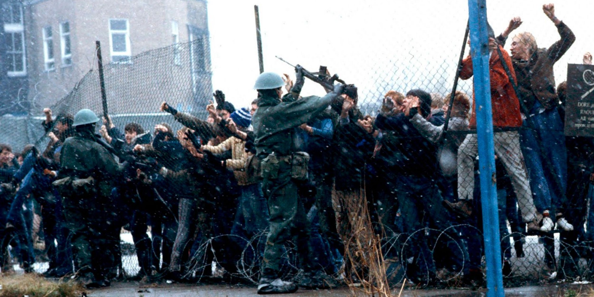 A group of protestors piling up against a fence in the nuclear war movie Threads