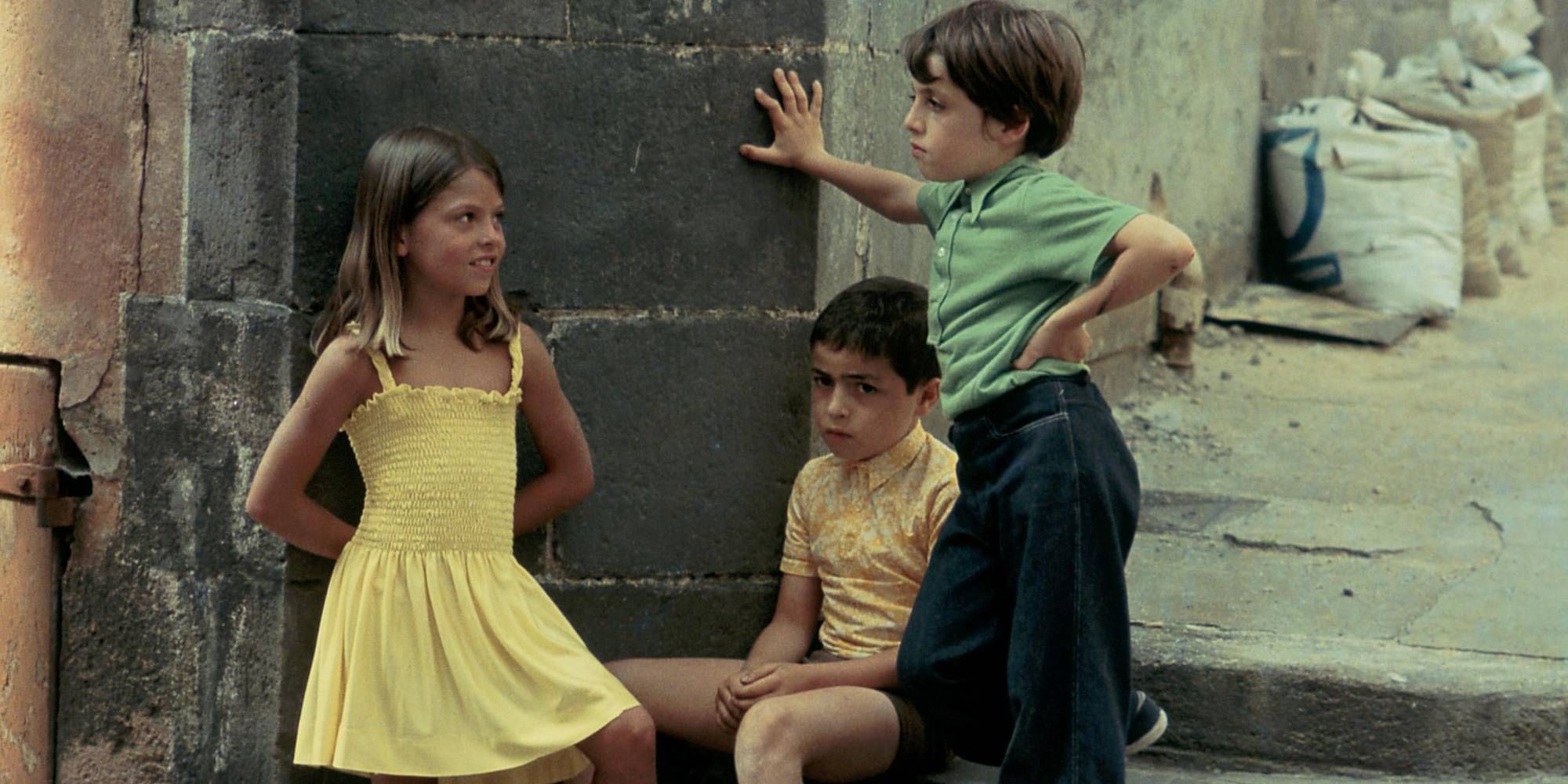 Tres niños junto a una pared en la calle en Small Change