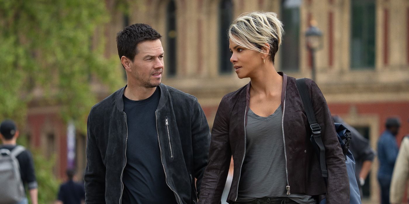 Mark Wahlberg and Halle Berry as Mike and Roxanne, looking at each other while walking through the street in Netflix's The Union