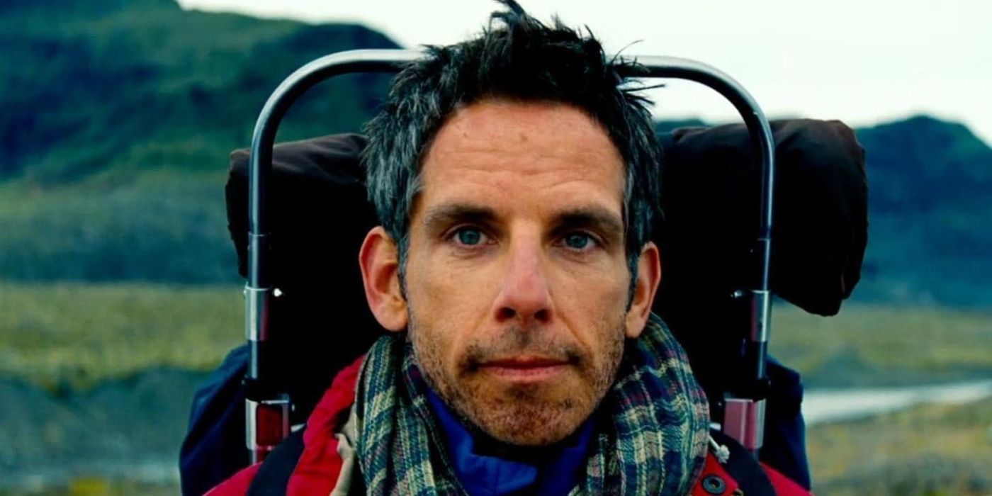Ben Stiller as Walter Mitty faces the camera with mountains in the background wearing a hiking backpack in The Secret Life of Walter Mitty