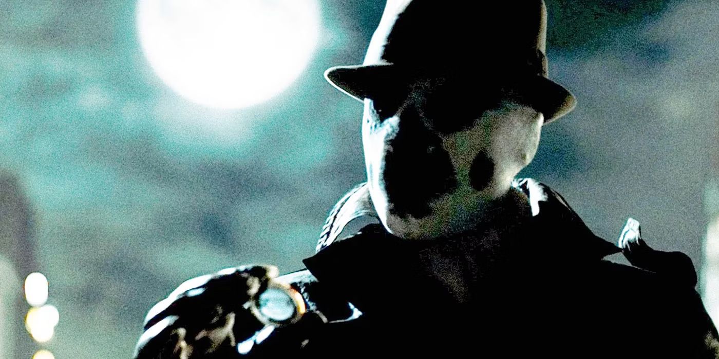 Rorschach (Jackie Earle Hailey) stands looking at a bloodied badge while the full moon glistens behind him in 'Watchmen' (2009).