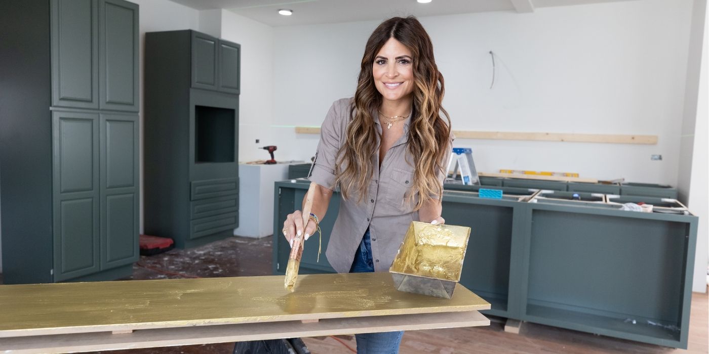 Alison Victoria painting a table and smiling for the camera