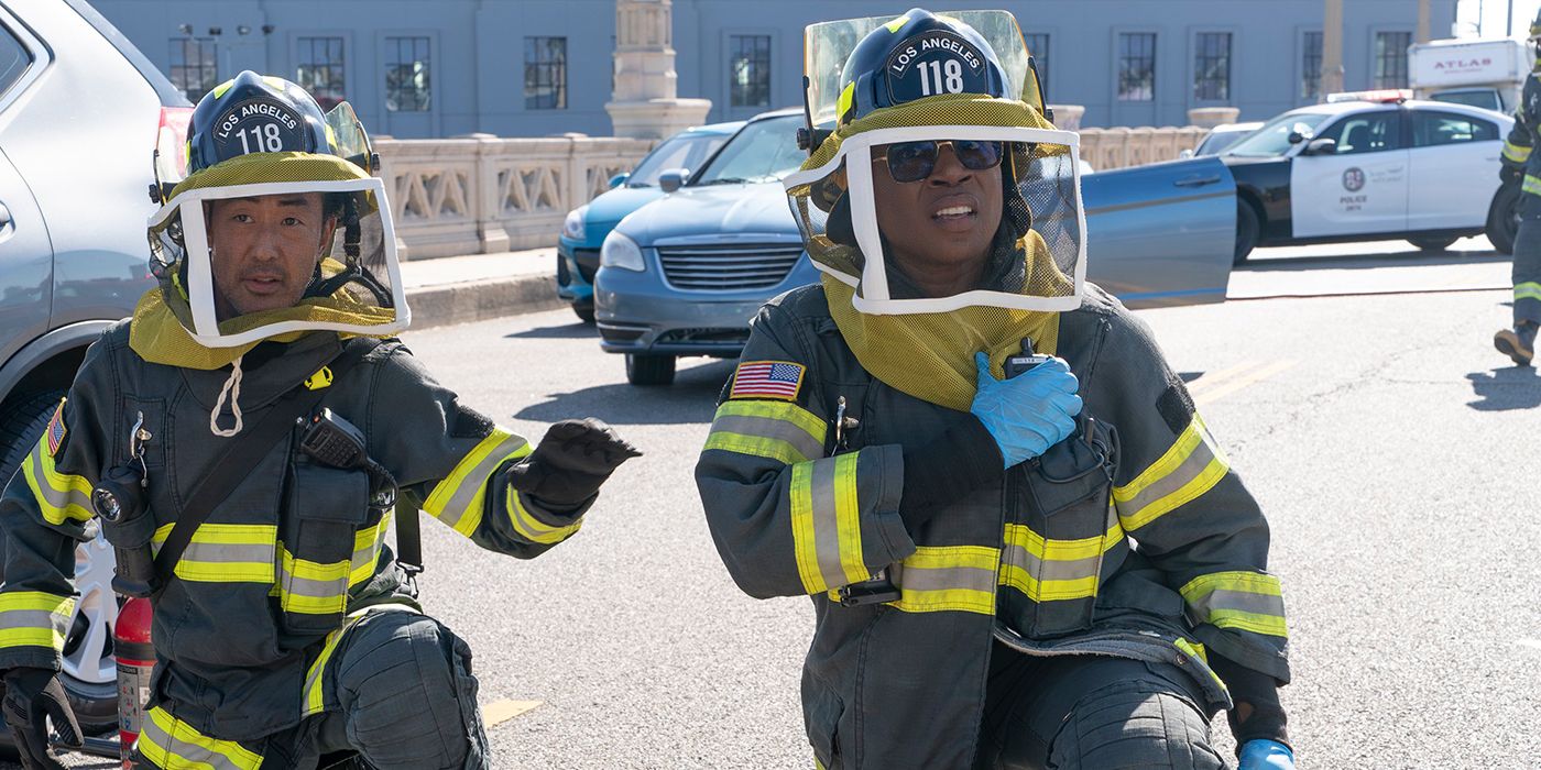 Kenneth Choi as Chim and Aisha Hinds as Hen looking at a swarm of bees in their firefighter gear with their beekeeping nets over their face in 9-1-1