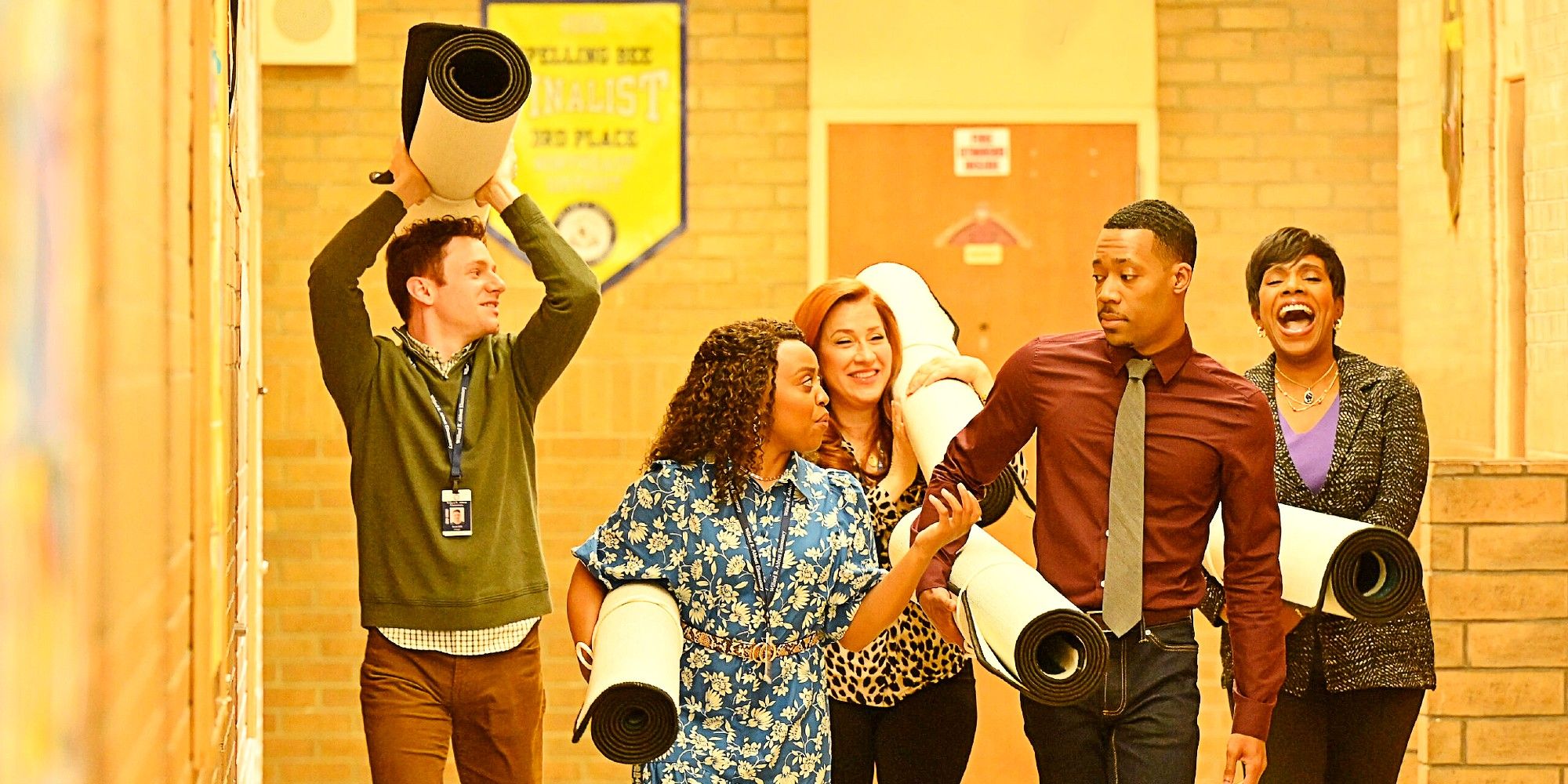 Jacob, Janine, Melissa, Gregory, and Barbara smiling and carrying rugs in the pilot episode of Abbott Elementary