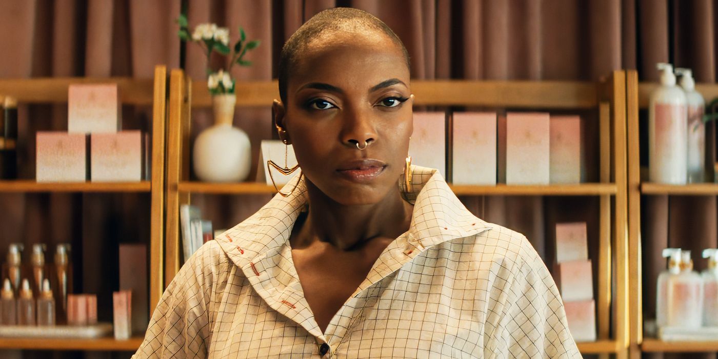 Sasheer Zamata looking toward the camera intensely in front of beauty products