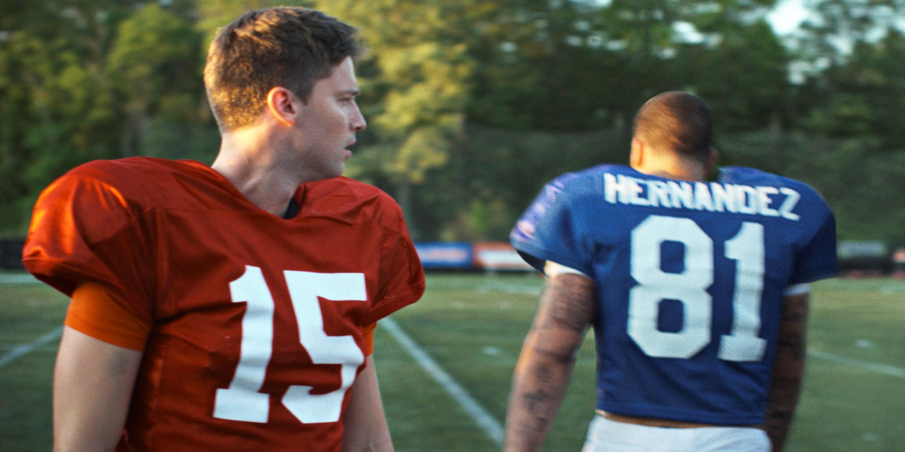 Patrick Schwarzenegger as Tim Tebow walking past Josh Rivera on the field in American Sports Story