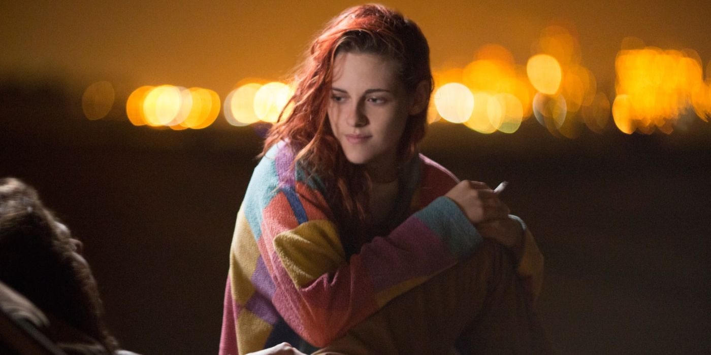 Phoebe (Kristen Stewart) sits in a cozy sweater at night while she smokes a cigarette in 'American Ultra' (2015).