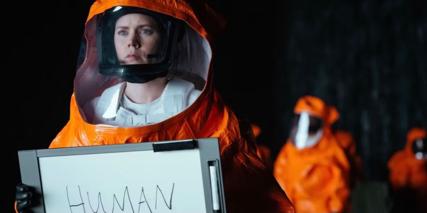 Amy Adams llega vestida con un traje de materiales peligrosos y sosteniendo un cartel con estas palabras. "humano".