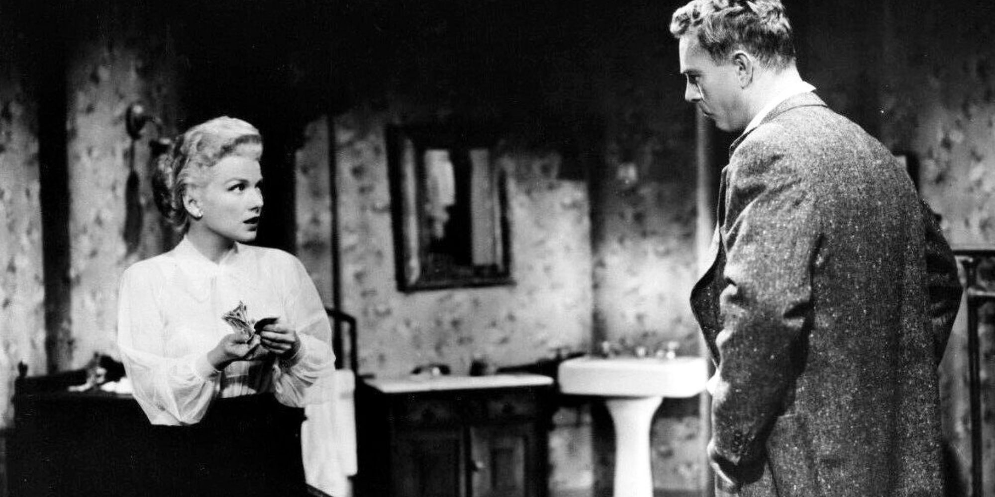 Anne Baxter standing across from Sterling Hayden both looking at each other in The Come On (1956)