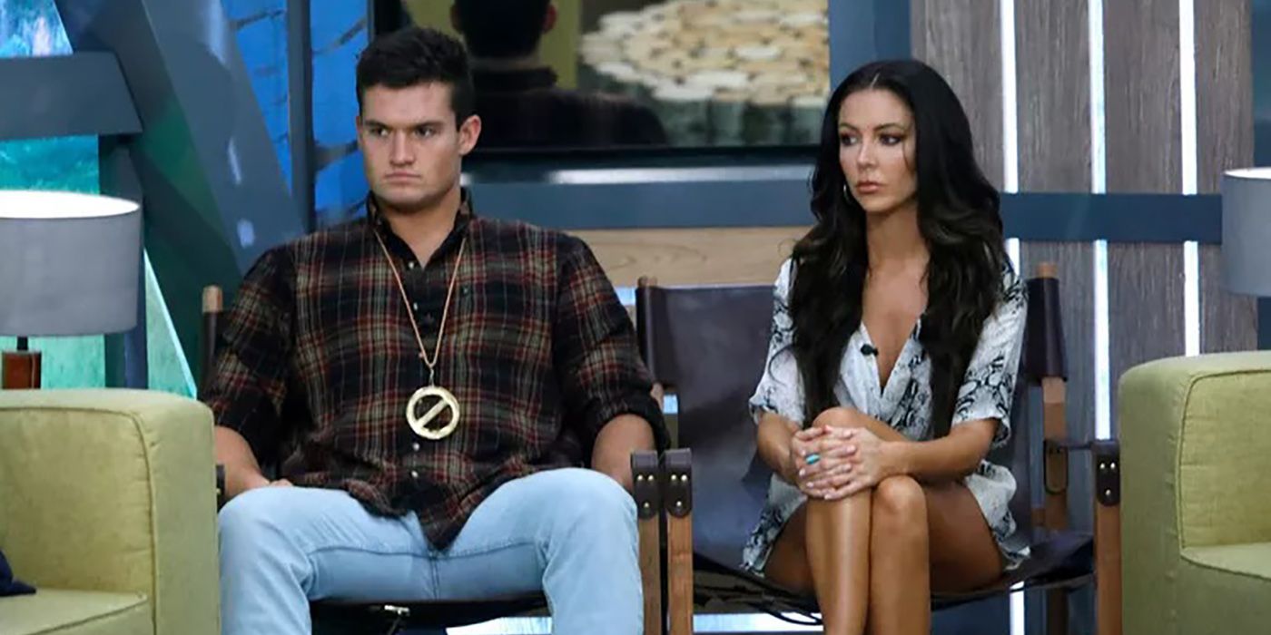 Jackson and Holly sitting next to one another in the Big Brother house, both looking angry and Jackson with the Veto necklace.