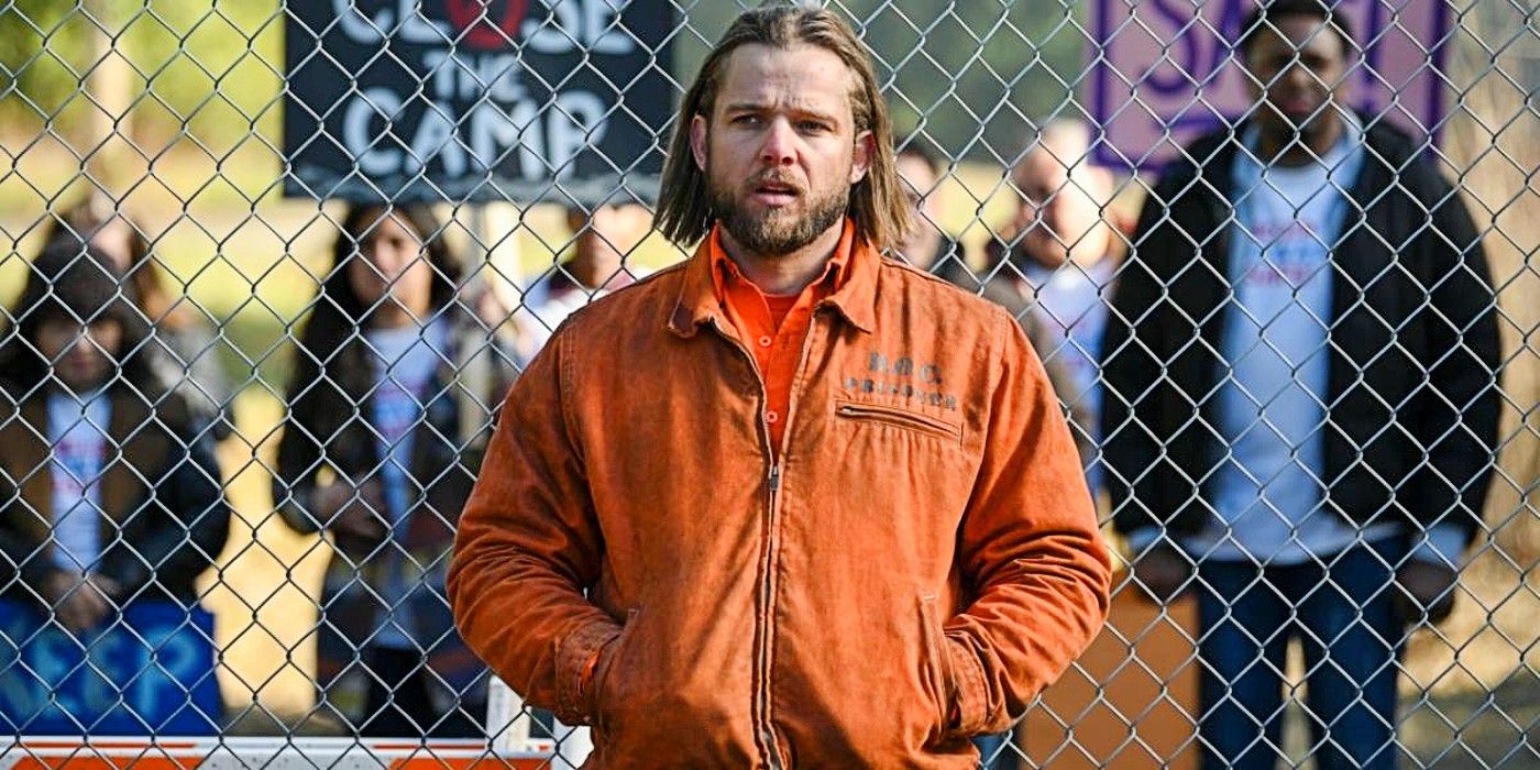 Bode leaning against a fence that blocks out protestors with signs to close Three Rock in Fire country Season 2