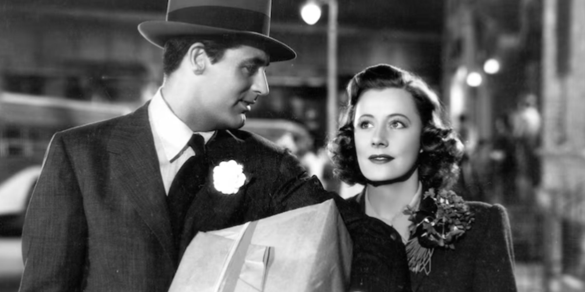 Cary Grant holding a package and walking next to Irene Dunne in Penny Serenade (1941)