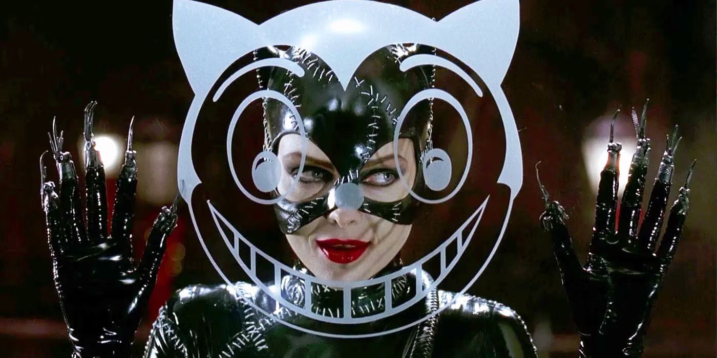 Michelle Pfeiffer stands in front of a cat logo on a window in Tim Burton's 'Batman Returns'