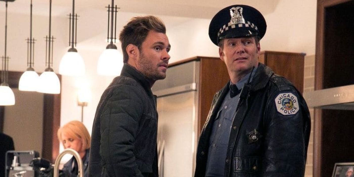 Two police officers talk to each other inside the precinct office on Chicago P.D.