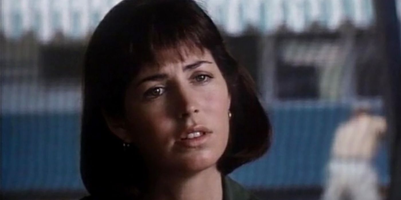 Nurse Colleen in China Beach with her head titled to the side, short hair with bangs.