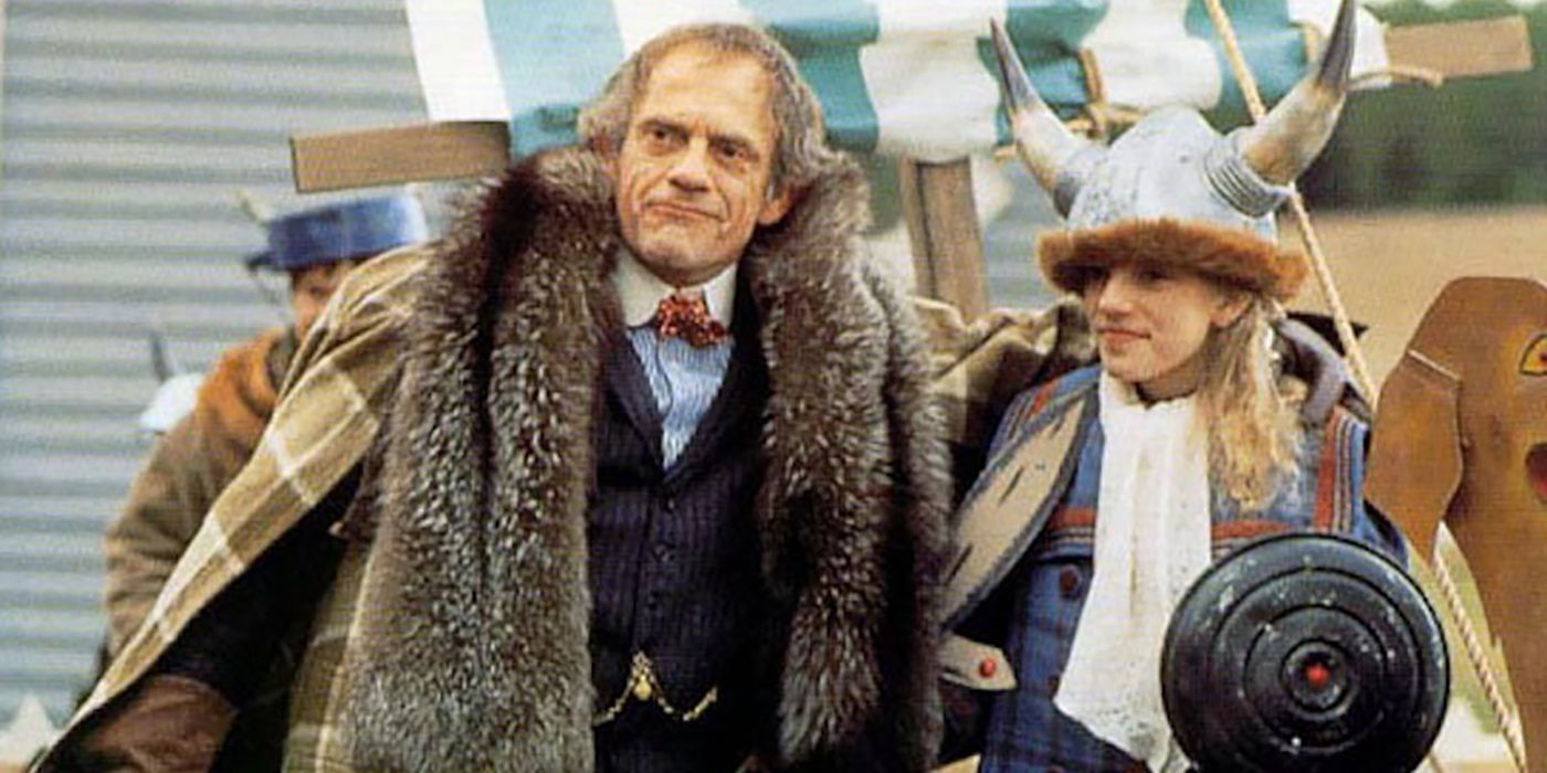 Christoper Lloyd with a big fur jacket walking with a young girl with a hat with horns in Road to Avonlea.