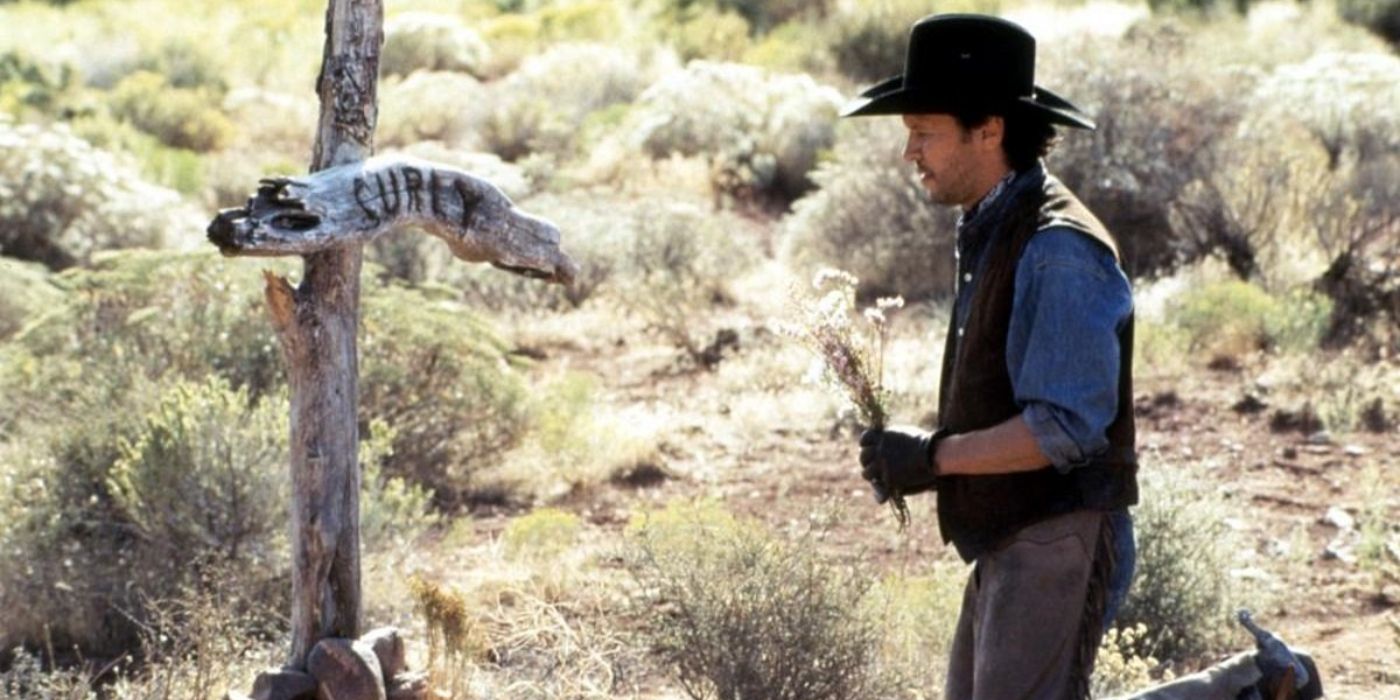 Mitch Robbins (Billy Crystal) kneels at the grave of his friend in 'City Slickers II' (1994).