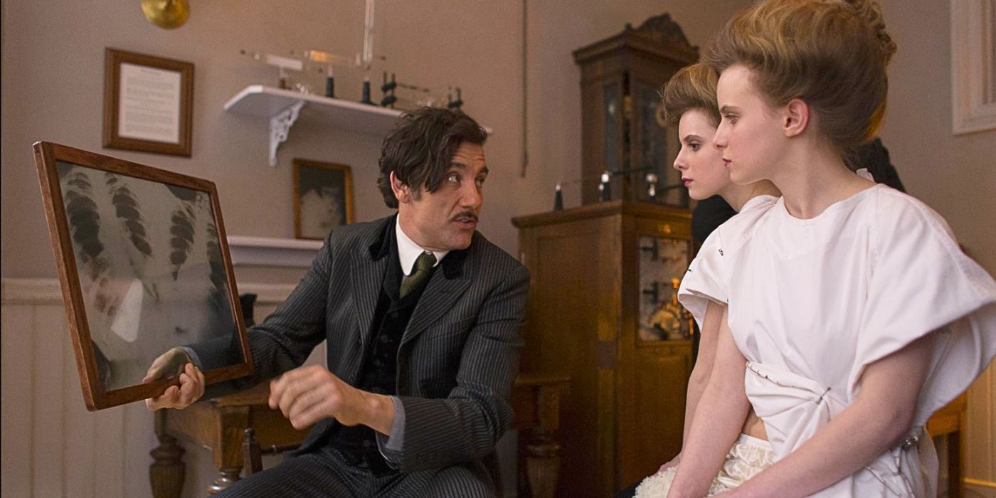 Dr. John Thackery consults with Siamese twins as he explains their connection points on an X-ray in the series The Knick