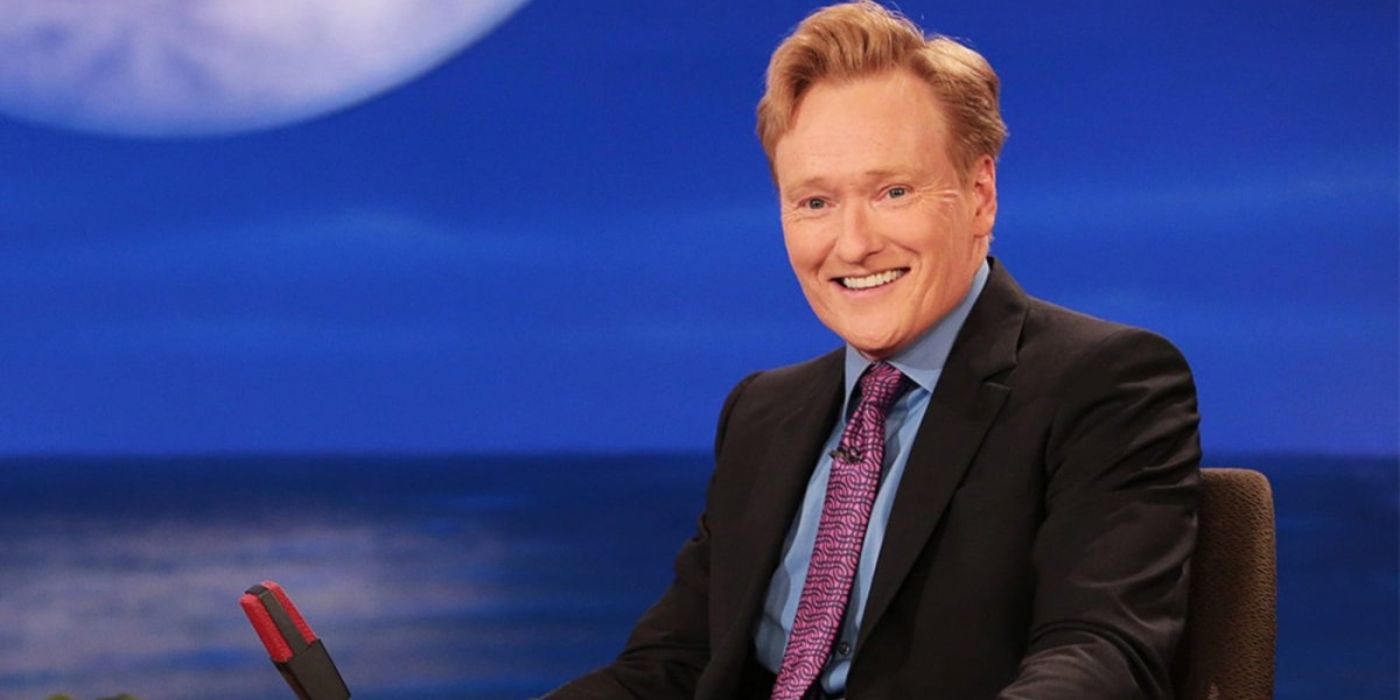 Conan O'Brien is all smiles as he sits behind his desk on set as the host of 'Conan' on TBS.