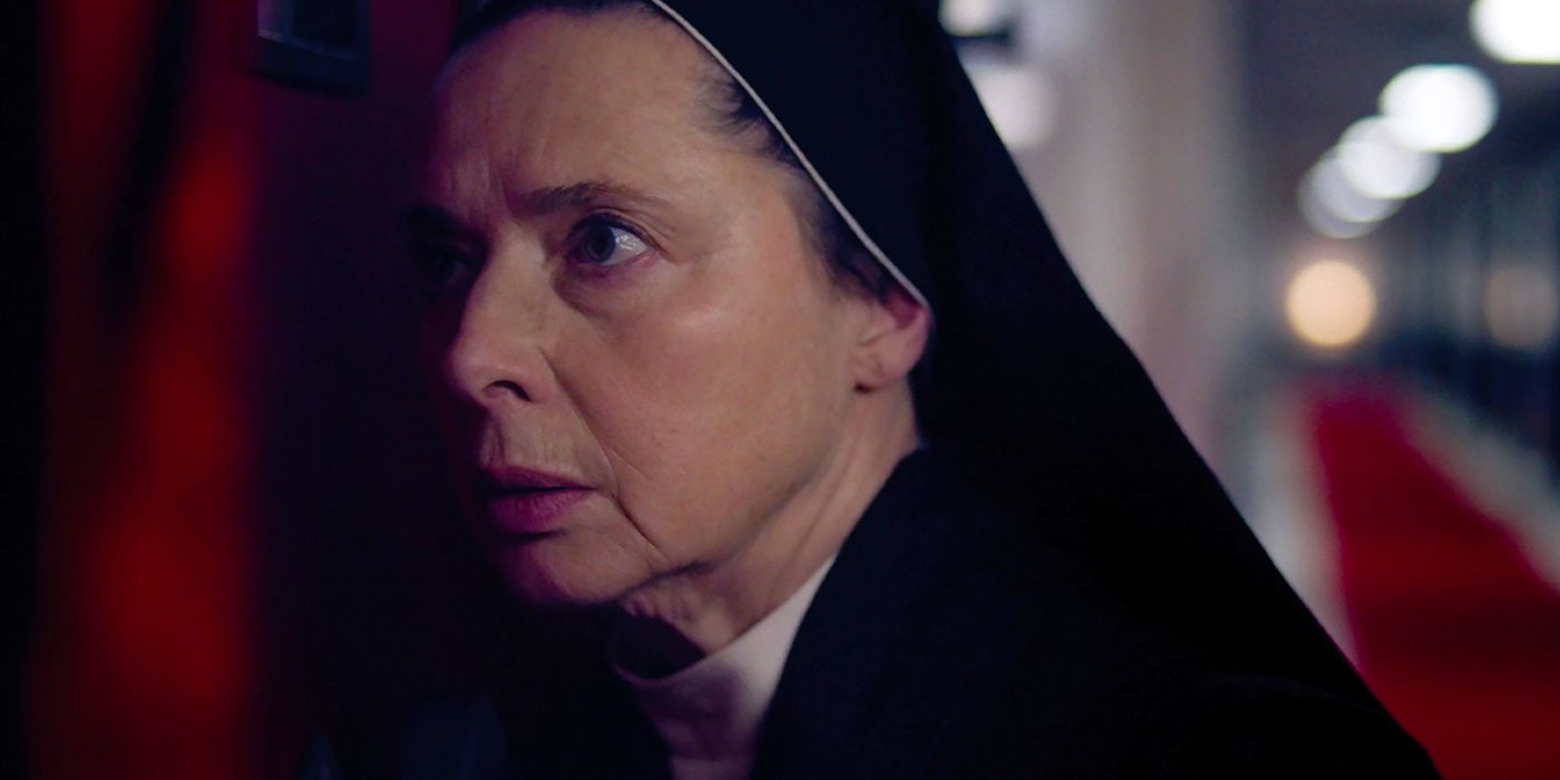 Isabella Rossellini as Sister Agnes listening against a door in shock in Conclave