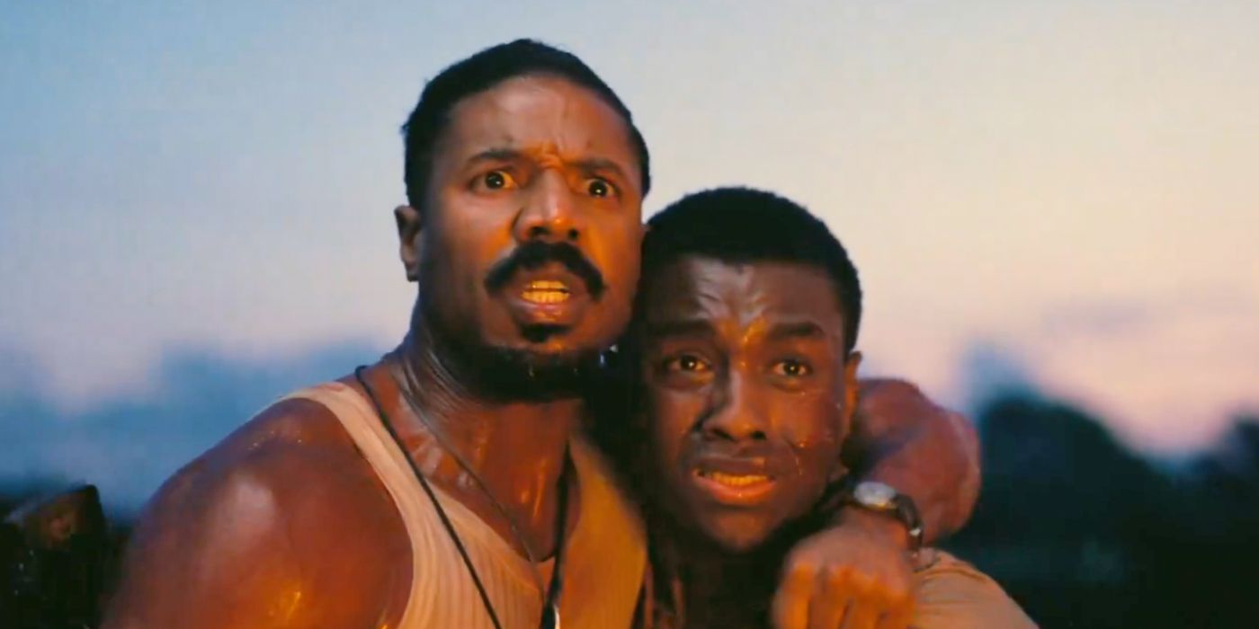 Michael B. Jordan with his arm around another man with scared looks in Sinners.