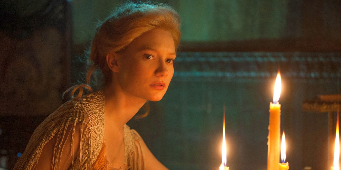 Edith Cushing sitting near lit candles and looking offscreen toward the left in Crimson Peak