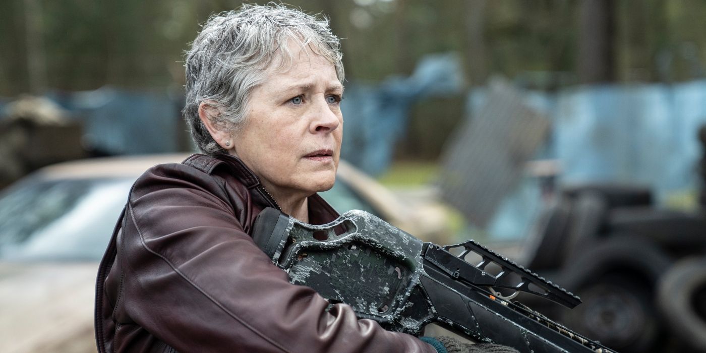 Melissa McBride holding a rifle among run-down cars in Daryl Dixon Season 2 - The Book of Carol