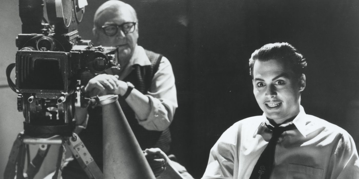 Johnny Depp as Ed Wood sits and smiles near Norman Alden as cameraman Bill, who looks at him in Ed Wood