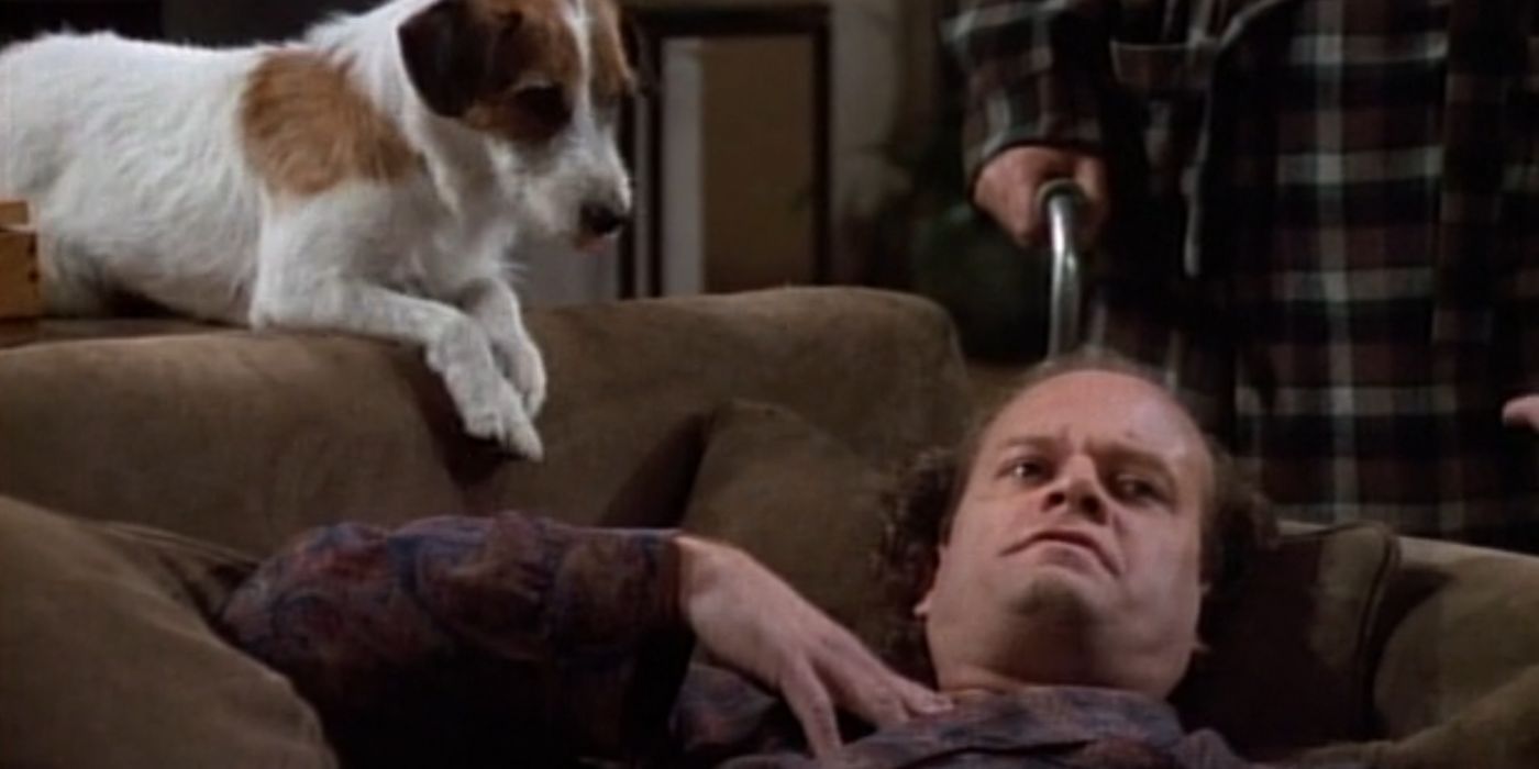 Frasier, wearing his pajamas and robe, is laying down on the couch. He looks very worried. Eddie is sitting on the back of the sofa. Martin is standing over Frasier.