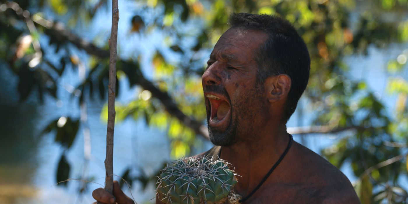 Gary Goldin holds a plant and yells in Naked and Afraid.