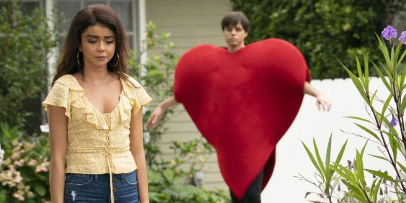 Dylan wears a big red heart costume and follows Haley, who looks sad in Modern Family.