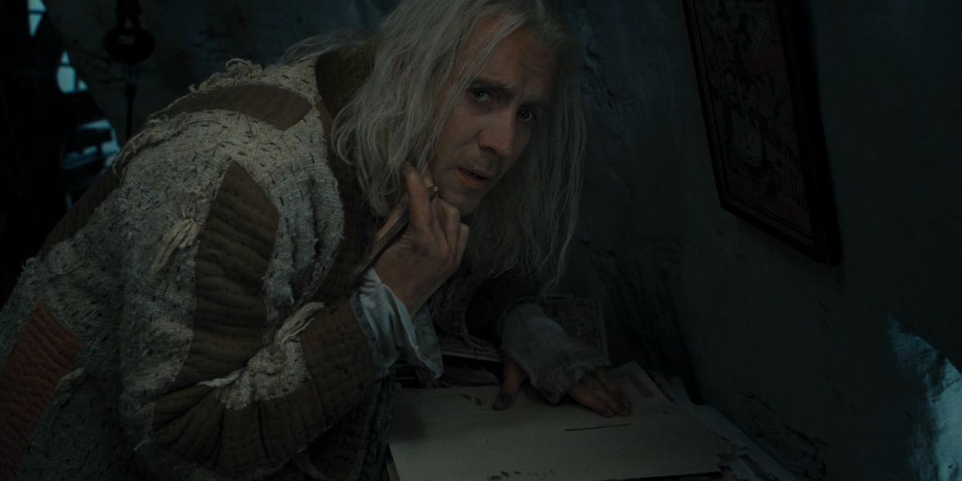 Xenophillius Lovegood (Rhys Ifans) sits at a desk looking concerned and sheepish in &lsquo;Harry Potter and the Deathly Hallows Part 1&rsquo; (2010).