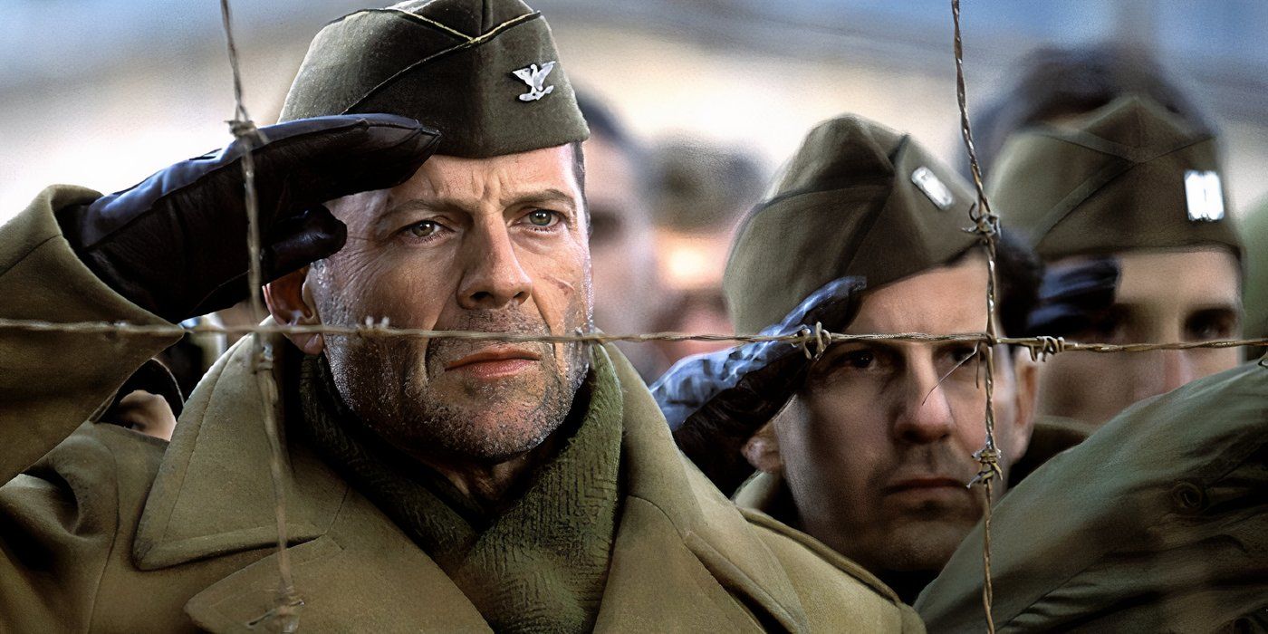 Bruce Willis as Col. William A. McNamara giving a salute from behind a barbed wire fence in Hart's War