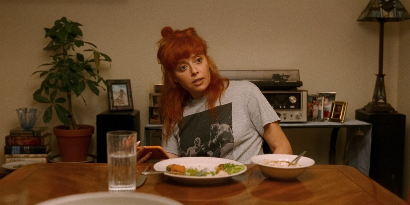 Natasha Lyonne sits at a dinner table looking annoyed in His Three Daughters