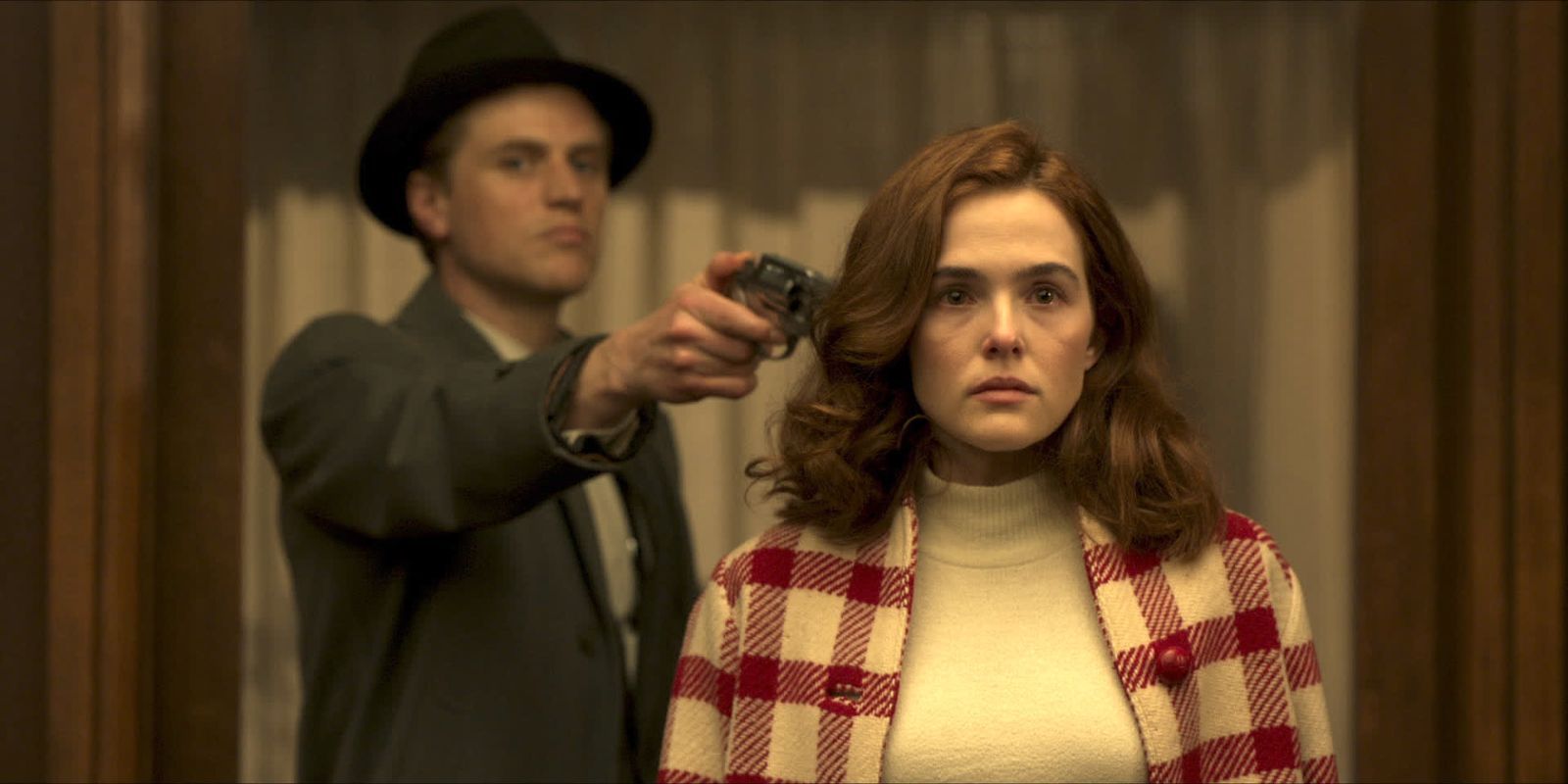 Francis aiming a gun at Mable's head in The Outfit